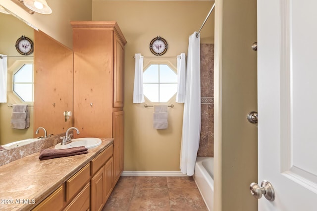 full bath with shower / tub combo with curtain, vanity, and baseboards