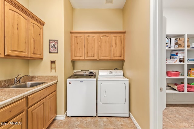 washroom featuring cabinet space, visible vents, baseboards, washing machine and dryer, and a sink