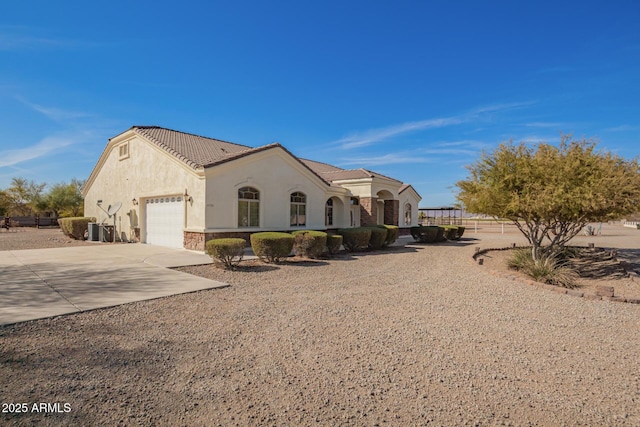 view of front of home with a garage, concrete driveway, stone siding, a tile roof, and stucco siding