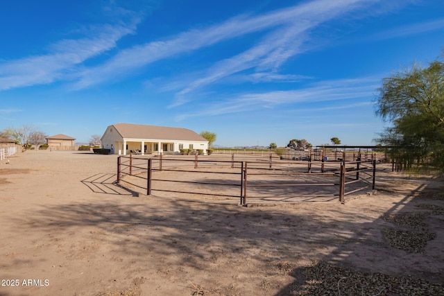 view of yard featuring a rural view, an exterior structure, and an outbuilding