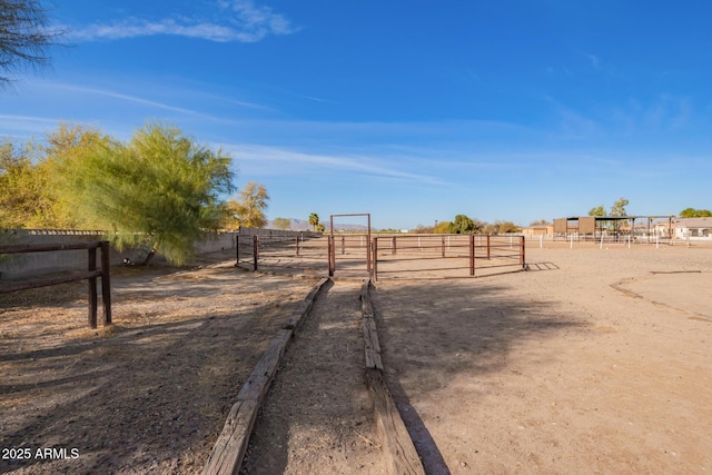 view of yard featuring a rural view, an enclosed area, and fence