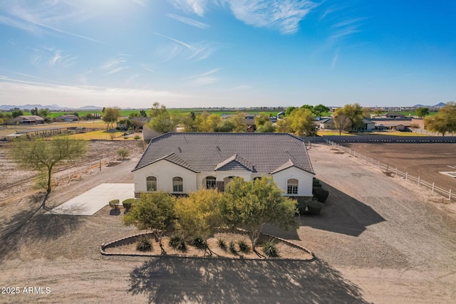 view of front of property with driveway, a tile roof, fence, and stucco siding