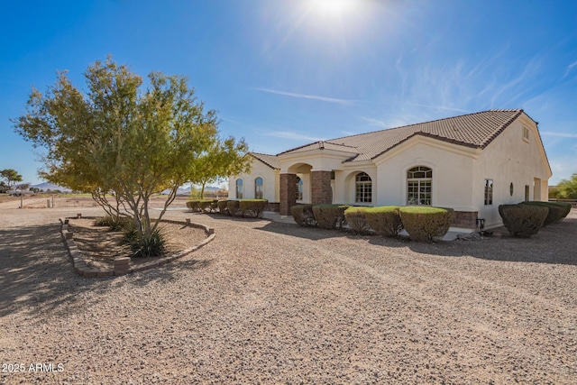 mediterranean / spanish-style home featuring a tile roof and stucco siding