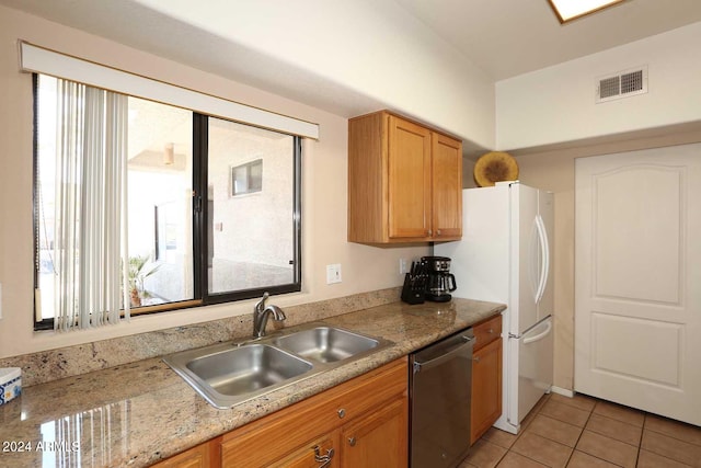 kitchen featuring sink, light tile floors, light stone counters, white refrigerator, and dishwasher