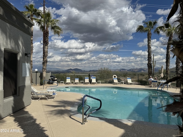 view of pool with a mountain view and a patio