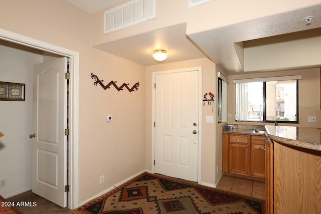 foyer featuring dark tile floors