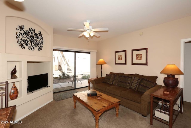 living room featuring dark colored carpet and ceiling fan