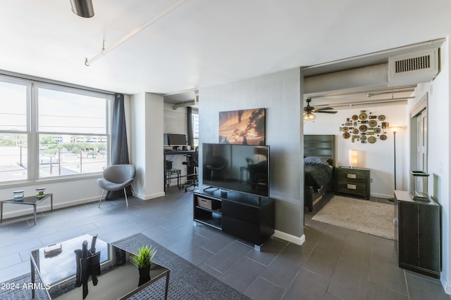 living room featuring ceiling fan and dark tile patterned flooring