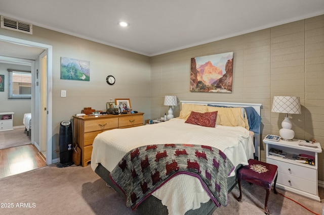 bedroom with ornamental molding and light carpet