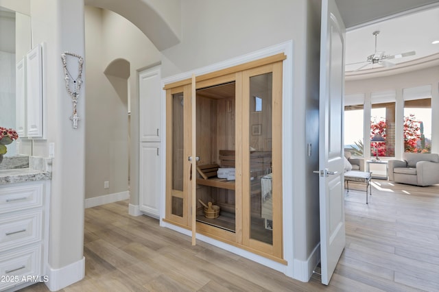 interior space with wood-type flooring, vanity, and ceiling fan