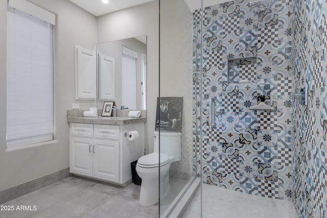 bathroom with vanity, tiled shower, tile patterned floors, and toilet