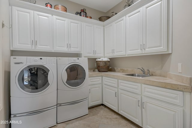 laundry area with cabinets, washing machine and dryer, sink, and light tile patterned flooring