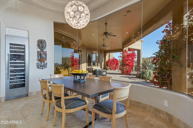 dining room featuring ceiling fan with notable chandelier and wine cooler