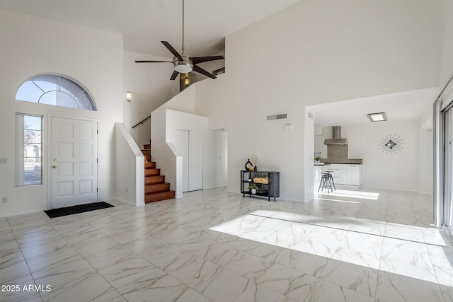 entryway with ceiling fan and a high ceiling