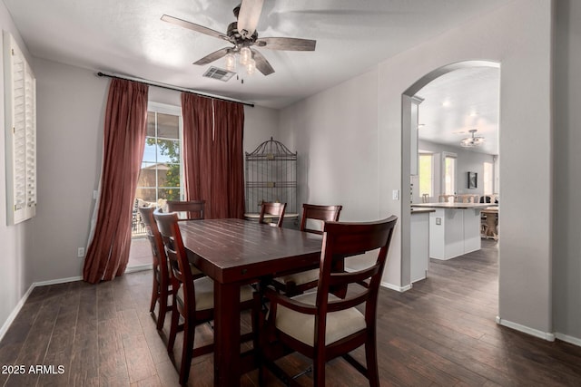 6862 W Honeysuckle Dr, Peoria, AZ 85383 - dining room featuring arched walkways, dark wood-style flooring, ceiling fan, and baseboards