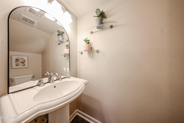 bathroom featuring vaulted ceiling and toilet