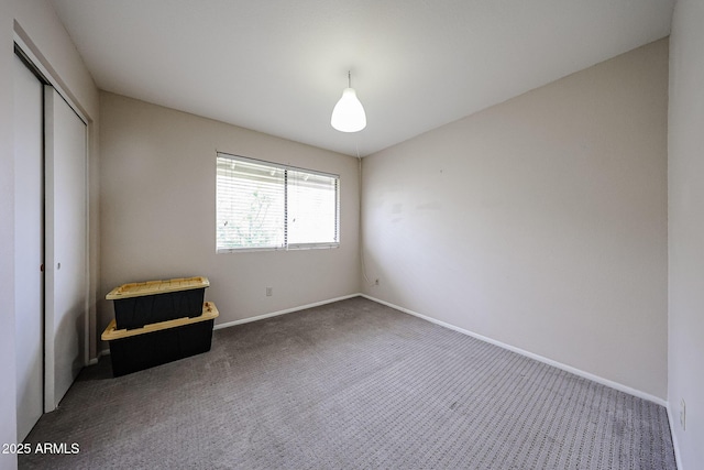 unfurnished bedroom with dark carpet and a closet