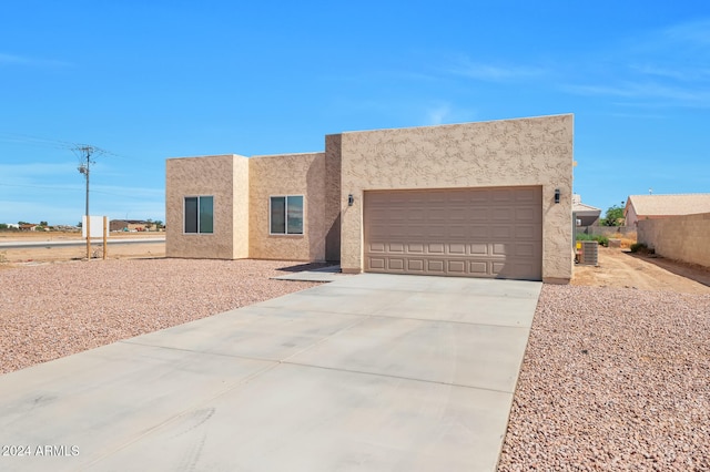 southwest-style home with a garage and central air condition unit