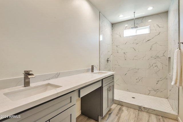 bathroom with tiled shower, vanity, and hardwood / wood-style flooring