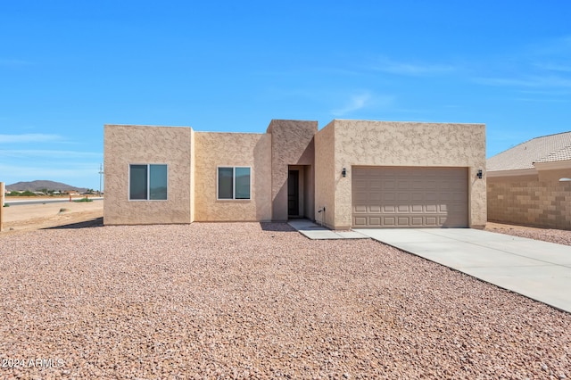 adobe home featuring a mountain view and a garage