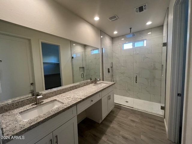 bathroom featuring hardwood / wood-style floors, vanity, and walk in shower