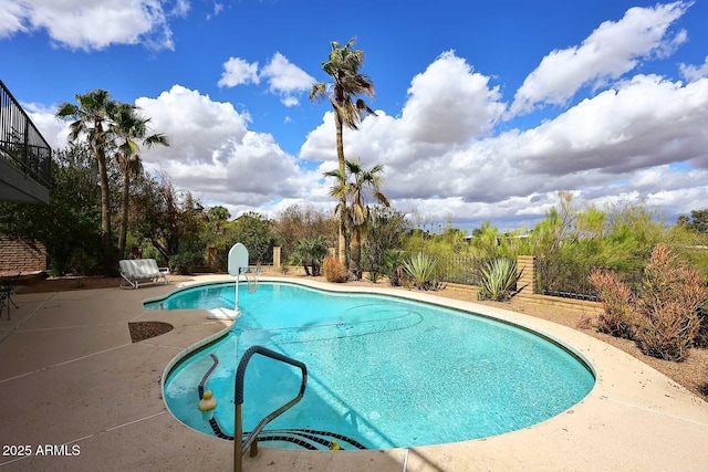 outdoor pool featuring a patio area and fence