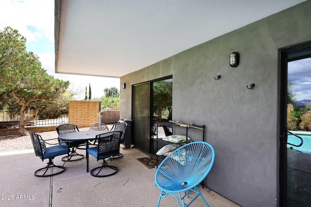 view of patio with outdoor dining space and fence