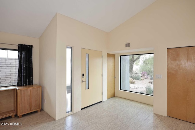 entryway with high vaulted ceiling and visible vents