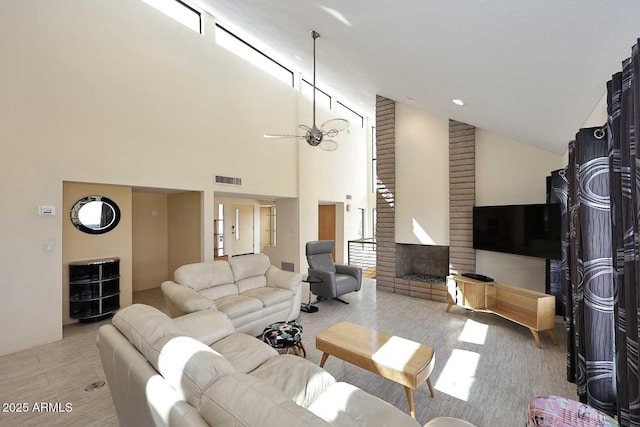 living room featuring lofted ceiling, a fireplace, wood finished floors, and visible vents