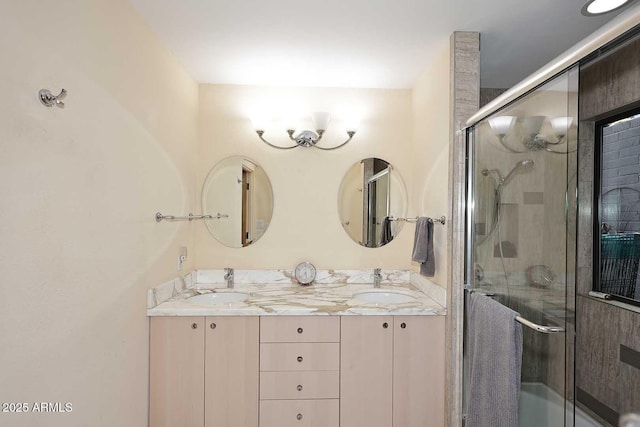 bathroom featuring a shower with door, a sink, and double vanity