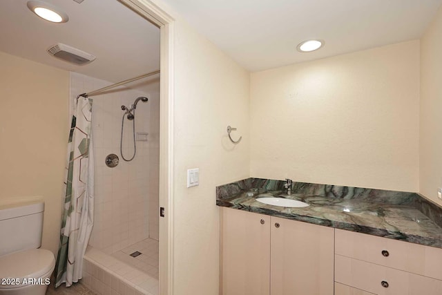 bathroom featuring visible vents, toilet, a tile shower, a sink, and recessed lighting