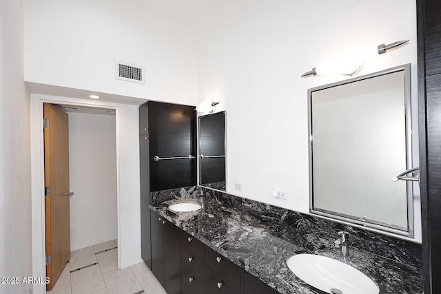 full bathroom featuring double vanity, a high ceiling, visible vents, and a sink