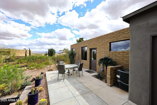 view of patio with central AC unit and outdoor dining space