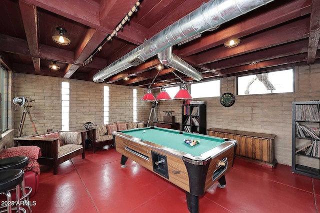 recreation room with brick wall, concrete flooring, and pool table