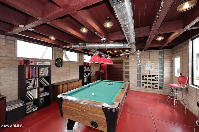 game room featuring brick wall, beamed ceiling, billiards, and concrete floors