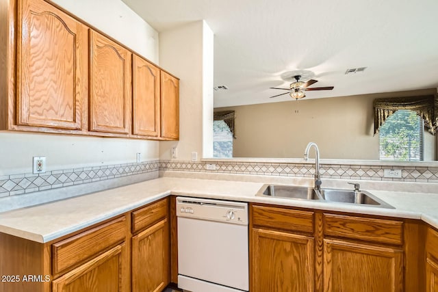 kitchen featuring a sink, visible vents, light countertops, dishwasher, and tasteful backsplash