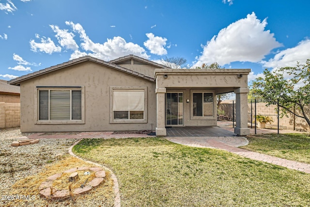 rear view of property with fence, a lawn, a patio, and stucco siding