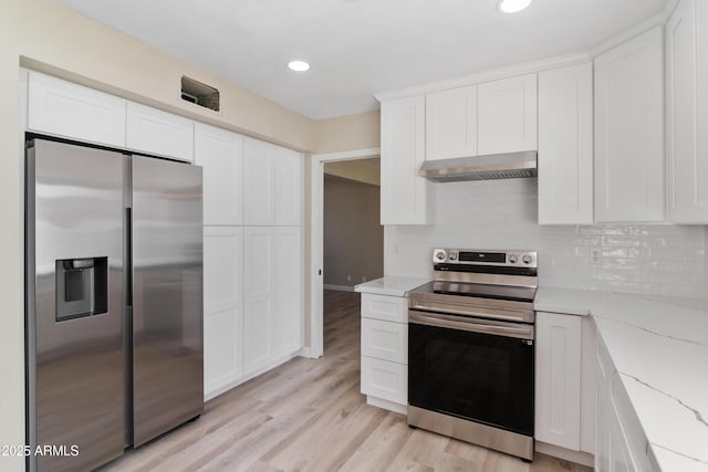 kitchen featuring light stone counters, stainless steel appliances, decorative backsplash, white cabinets, and exhaust hood