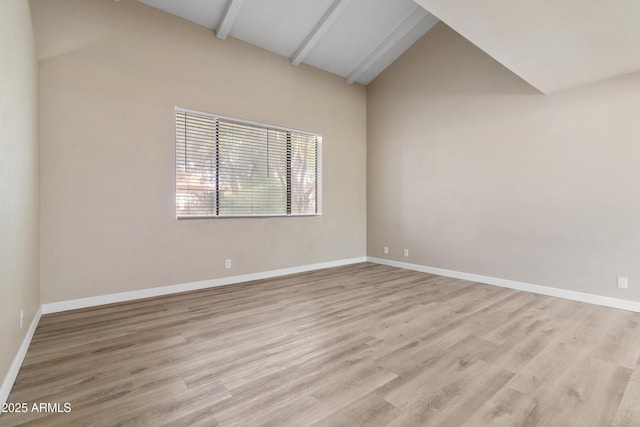 unfurnished room with baseboards, light wood-style flooring, and vaulted ceiling with beams