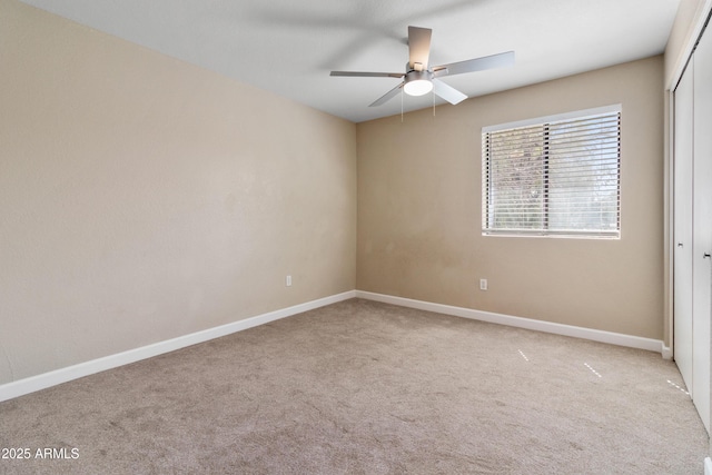 carpeted empty room featuring baseboards and ceiling fan