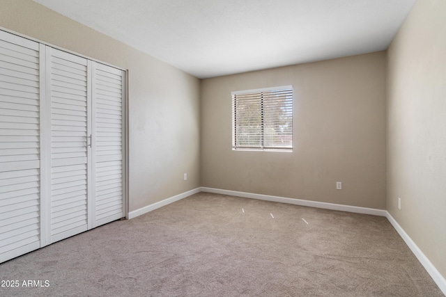 unfurnished bedroom featuring a closet, baseboards, and carpet floors