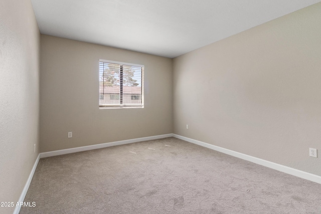 empty room featuring baseboards and carpet floors