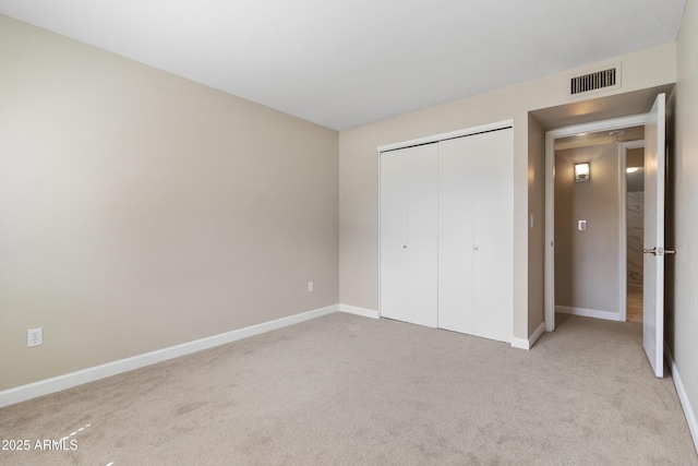 unfurnished bedroom featuring visible vents, baseboards, a closet, and carpet flooring