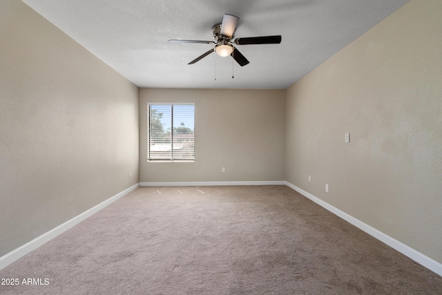 empty room with light colored carpet, baseboards, and ceiling fan