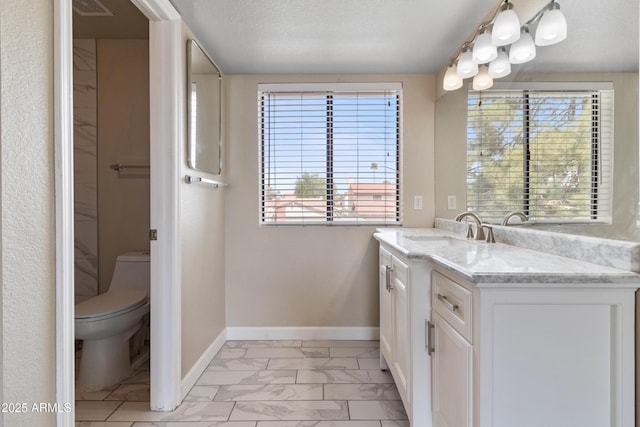 bathroom with vanity, baseboards, a textured ceiling, toilet, and marble finish floor