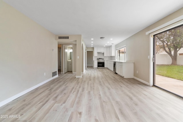 unfurnished living room featuring light wood-style flooring, recessed lighting, baseboards, and visible vents