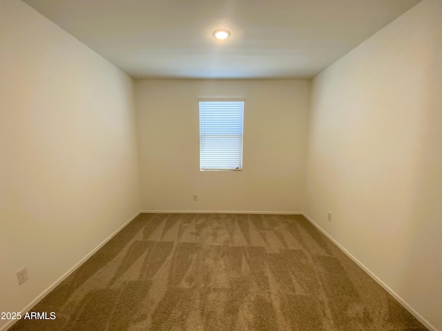 empty room featuring carpet floors and baseboards