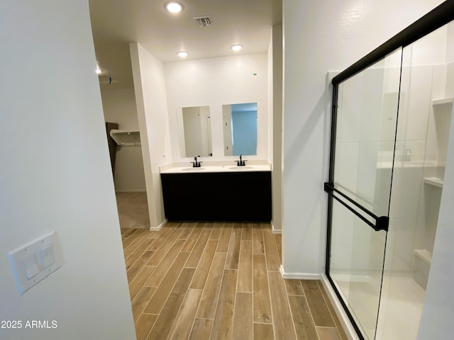 full bath featuring a stall shower, a sink, and wood tiled floor