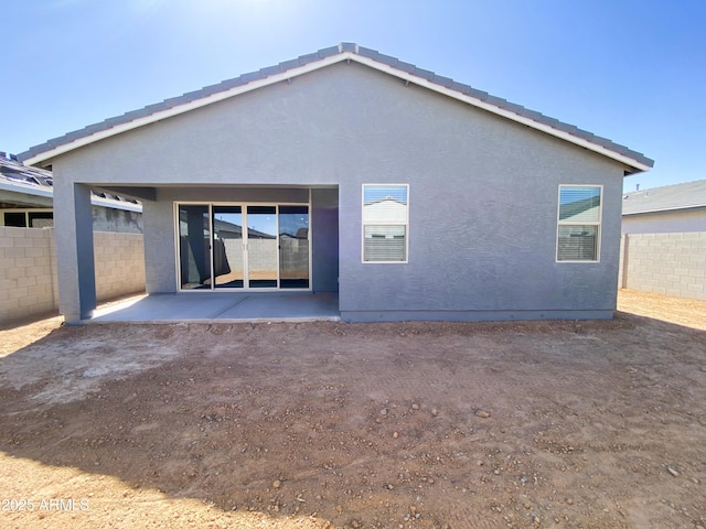 back of house with a patio, fence, and stucco siding