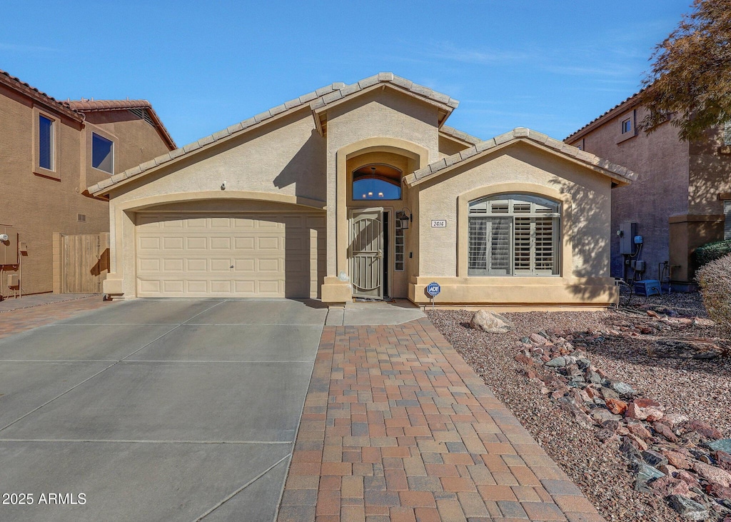 2414 W White Feather Ln, Phoenix, AZ 85085 - mediterranean / spanish house with a tile roof, stucco siding, an attached garage, and concrete driveway